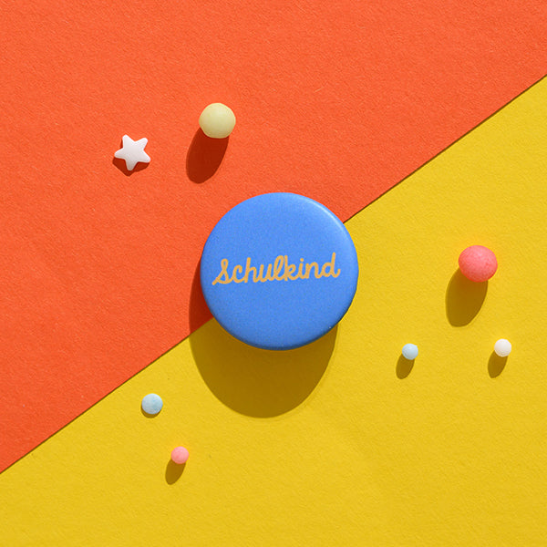 Ava & Yves - Schulkind Button Senf mit Hintergrund blau